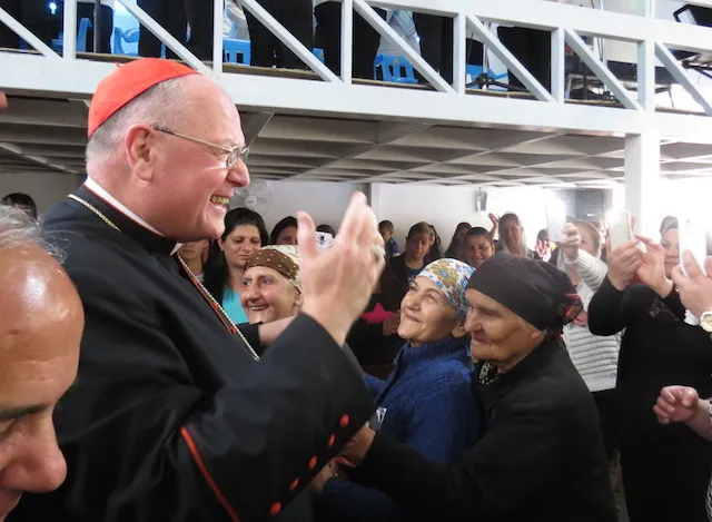 Cardinal Dolan greets Iraqis in the village of Inishke before Mass on April 10, 2016. Credit: Elise Harris/CNA.