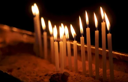Candles lit in the Church of the Holy Sepulchre in Jerusalem, Israel. Credit: Lauren Cater/CNA.