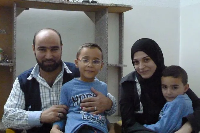 Syrian refugee and Caritas Jordan volunteer Amer Fahd Al Naser, his wife Noor, and their sons, at their apartment in Jordan, October 2014. Credit: Kevin Jones/CNA.