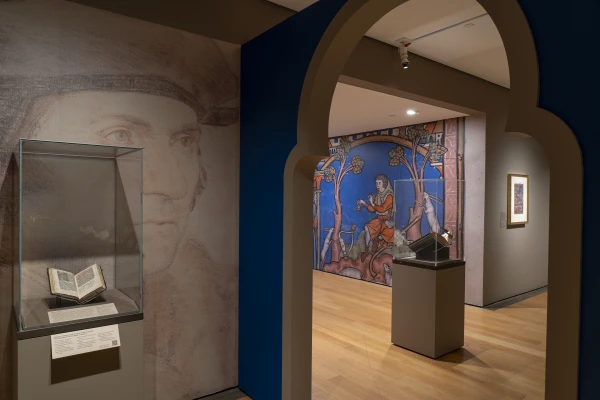 The Prayer Book of Thomas More is backed by a wall-sized image of Hans Holbein’s "Sir Thomas More," positioned to look like More is gazing intently across the gallery at an image of David from the Crusader Bible. Engelhard Gallery, Photography by Janny Chiu, October 2025. Credit: Courtesy of the New York Library