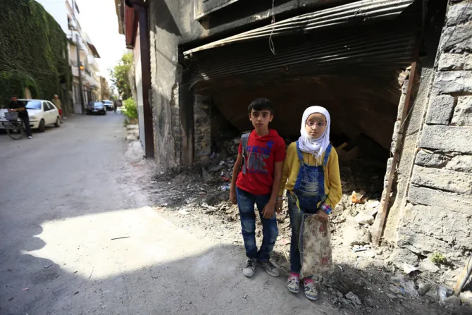 12 year old twins from the old city of Homs stand near garbage outside a dilapidated building Credit   UNICEF UNI201161 Ohanesian CNA 1 13 16