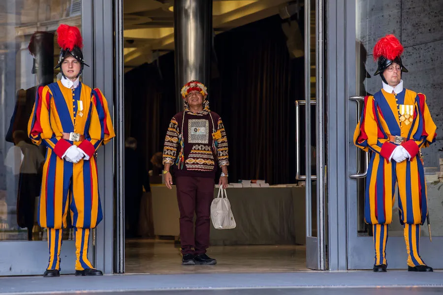 A participant in the Vatican's Amazon synod is flanked by two members of the Swiss Guard. ?w=200&h=150