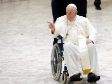 Pope Francis greets the crowd in a wheelchair at his general audience, Aug. 3, 2022.