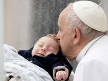 Pope Francis kisses a baby during his weekly general audience on May 10, 2023.