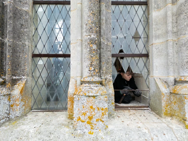 A worker restores windows in the north tower of the basilica at the Shrine of Our Lady of Montligeon in September 2025, part of a multiyear renovation project. Credit: Shrine of Our Lady of Montligeon