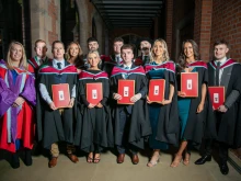 Graduates pose with their degrees at St. Mary’s University College in Belfast, Northern Ireland.