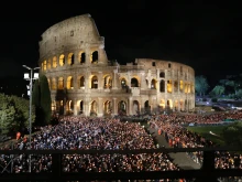 Thousands of faithful bearing candles surround the illuminated Colosseum in Rome during the traditional Via Crucis ceremony on Good Friday, April 18, 2025, where Cardinal Reina presided over the solemn procession.