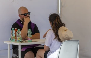 A priest listens to a penitent during confession during a reconciliation event at the Circus Maximus, Rome, Friday, Aug. 1, 2025 Credit: Daniel Ibáñez/CNA