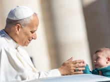 Pope Leo XIV greets a baby at his general audience in St. Peter's Square at the Vatican, Wednesday, Oct. 8, 2025.