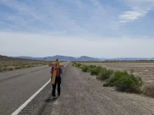 John Moore bears a cross along US 50 in Nevada during his cross-country pilgrimage. 