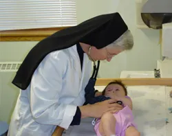A Religious Sister of Mercy of Alma, MI cares for a child.?w=200&h=150