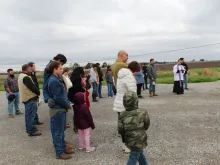 Father Matthew Barzare blesses water at an airfield in Cow Island, La., Dec. 21, 2019. Photo courtesy of the Diocese of Lafayette.