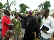 Archbishop Dieudonné Nzapalainga of Bangui blesses an ex-Seleka figher at Camp Beal. 