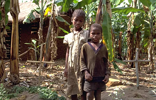 AIDS orphans Dominic, 7, and her sister Reticia, 10, standing between parent's graves in this December 2000 file photo. ?w=200&h=150