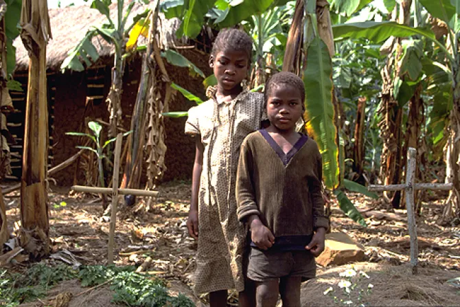 AIDS orphans Dominic 7 and her sister Reticia 10 standing between parents graves in this December 2000 file photo Credit UN Photo Louise Gubb CNA 2 12 14