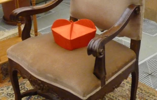 A cardinal's biretta rests on an empty chair.   Alan Holdren / CNA.