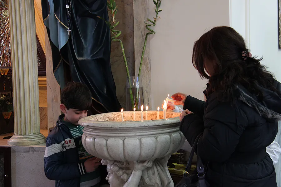 A Christian refugee family lights a candle at Mary, Mother of the Church parish in Amman, Jordan. ?w=200&h=150