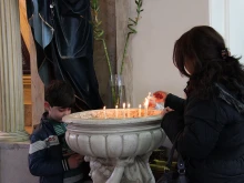 A Christian refugee family lights a candle at Mary, Mother of the Church parish in Amman, Jordan. 