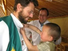 A Mongolian child helping Fr. Giorgio Marengo, IMC. 