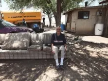 A Navejo elder sits in her yard while water is delivered to her home in Smith Lake, NM. 