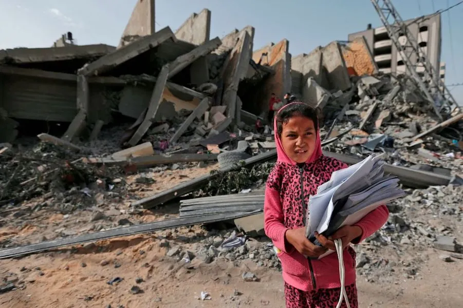 A Palestinian girl stands in front of a building destroyed during Israeli airstrikes in Gaza City. May 6, 2019. ?w=200&h=150