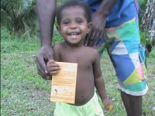 A Papua New Guinean child holds a Tarungu Appeal envelope for the poor. 
