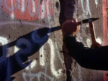 A West German man uses a hammer and chisel to chip off a piece of the Berlin Wall as a souvenir in November 1989 (Credi: U.S. Department of Defense).