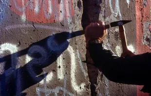 A West German man uses a hammer and chisel to chip off a piece of the Berlin Wall as a souvenir in November 1989 (Credi: U.S. Department of Defense). 