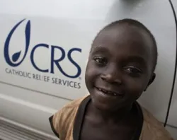 A boy stands beside a CRS vehicle in the village of Katooke in western Uganda. Photo by CRS staff.?w=200&h=150