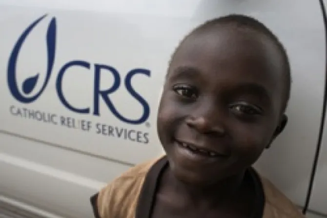 A boy stands beside a CRS vehicle in the village of Katooke in western Uganda Photo by CRS staff CNA 11 30 12