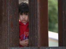 A child on the Mexican side of the U.S.-Mexico border watches the 'Mass on the Border' in Nogales, Arizona, April 1, 2014. 