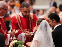 A newly married couple receive Communion at a Mass in St. Peter's Basilica, Sept. 14, 2014. 