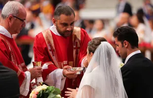A couple newly married by Pope Francis receives communion in St. Peter's Basilica on Sept. 14, 2014.   Lauren Cater/CNA.