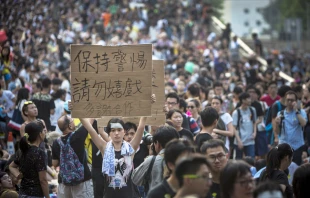 A demonstrator holds a sign as thousands pack the streets of Hong Kong in protest Oct. 1, 2014.   Paula Bronstein/Getty Images News-Getty Images.
