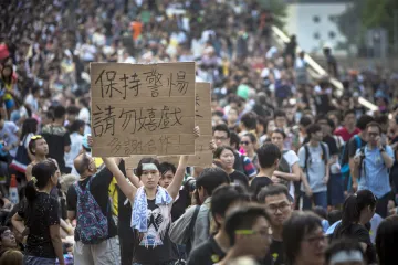 A demonstrator holds a sign as thousands pack the streets of Hong Kong in protest October 1 2014 Credit Paula Bronstein Getty Images News Getty Images CNA 10 2 14
