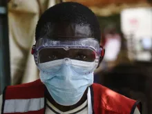 A health worker wears protective gear at a health screening facility in a Ugandan town bordering DRC. 