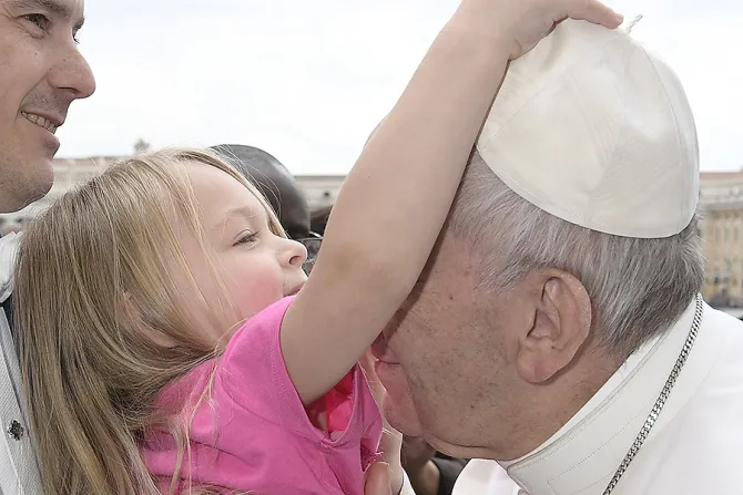 A little girl at the general audience greets Pope Francis and tries to take his zuchetto in St Peters Square on March 22 2017 Credit LOsservatore Romano CNA
