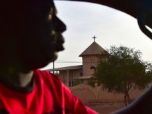 A man drives past a church in Ouahigouya, Burkina Faso. 