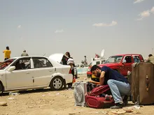 A man leaves his car and packs his bag at the Khazair checkpoint after fleeing from Mosul, Iraq on June 11, 2014. 