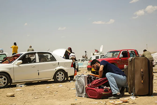 A man leaves his car and packs his bag at the Khazair checkpoint after fleeing from Mosul Iraq on June 11 2014 Credit R Nuri UNHCR ACNUR via Flickr CC BY NC SA 20 CNA 7 23 14