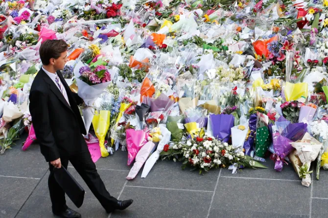 A man places flowers as a mark of respect for the victims of Martin Place siege on December 16 2014 in Sydney Australia Catholic News Agency Credit Getty Images Daniel Munoz 121614 CNA
