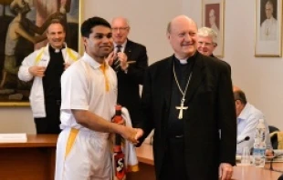 A member of St. Peter's Cricket Club greets Cardinal Gianfranco Ravasi during a June 23, 2014 press conference announcing their