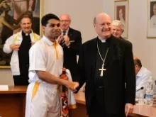 A member of St. Peter's Cricket Club greets Cardinal Gianfranco Ravasi during a June 23, 2014 press conference announcing their 