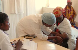 A nurse in a local clinic in Huambo Province, Angola, checks a patient and her baby /   USAID, Alison Bird