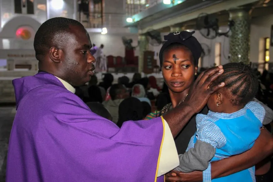 A priest signs the forehead of a child as catholics take part in the Ash Wednesday celebration at the St. Patrick cathedral in Maiduguri on February 26, 2020. ?w=200&h=150