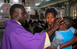 A priest signs the forehead of a child as catholics take part in the Ash Wednesday celebration at the St. Patrick cathedral in Maiduguri on February 26, 2020.   AFP/Getty