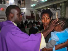 A priest signs the forehead of a child as catholics take part in the Ash Wednesday celebration at the St. Patrick cathedral in Maiduguri on February 26, 2020. 
