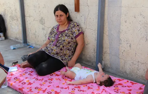 A refugee mother with her child, who is having stomach problems and other issues because of the heat. ?w=200&h=150