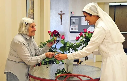 A resident and a sister arrange flowers at the Little Sisters of the Poor's Mullen Home in Denver, CO in this undated file photo. ?w=200&h=150