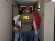 A suspect is taken into custody by FBI agents in Jackson, Mississippi during Operation Cross Country VIII in June 2014. 